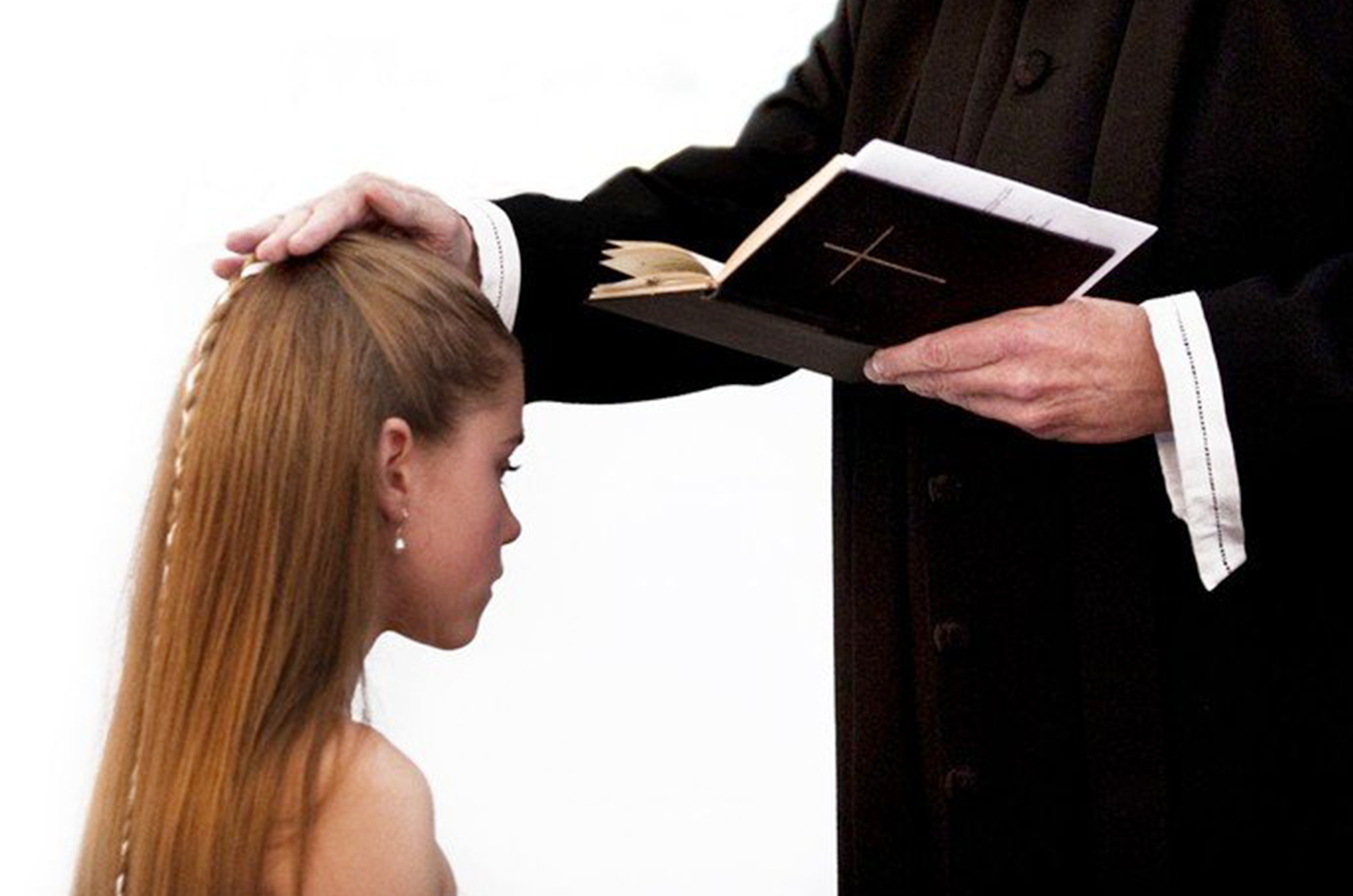 Geistlicher berührt Kopf einer Frau mit der Hand, während er ein Buch hält.