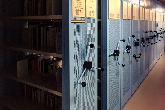 Lange Reihen von Archivschränken in einem dunklen Raum.