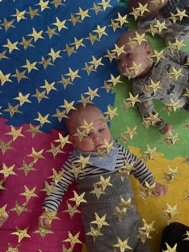 Mehrere Erwachsene und Babys bei einem Gruppentreffen.